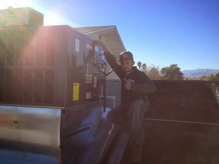 HVAC technician performing HVAC Inspection on a rooftop unit in Milledgeville